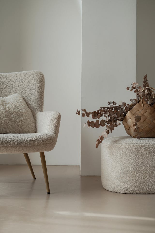 stylish white arm chair next to a plant