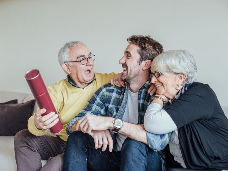 Son and parents celebrating on the couch