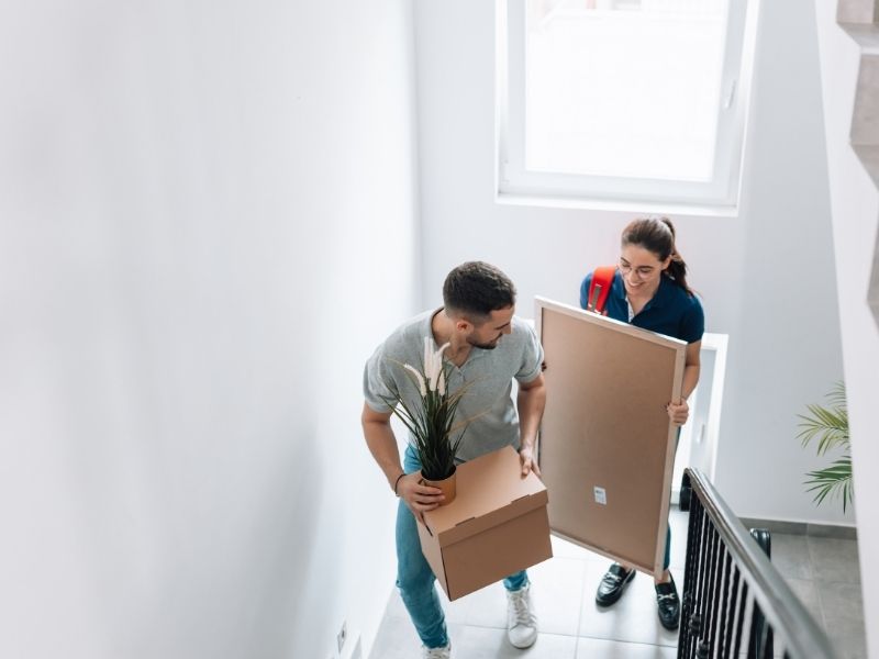 Man and woman moving into a new apartment with boxes in their hands